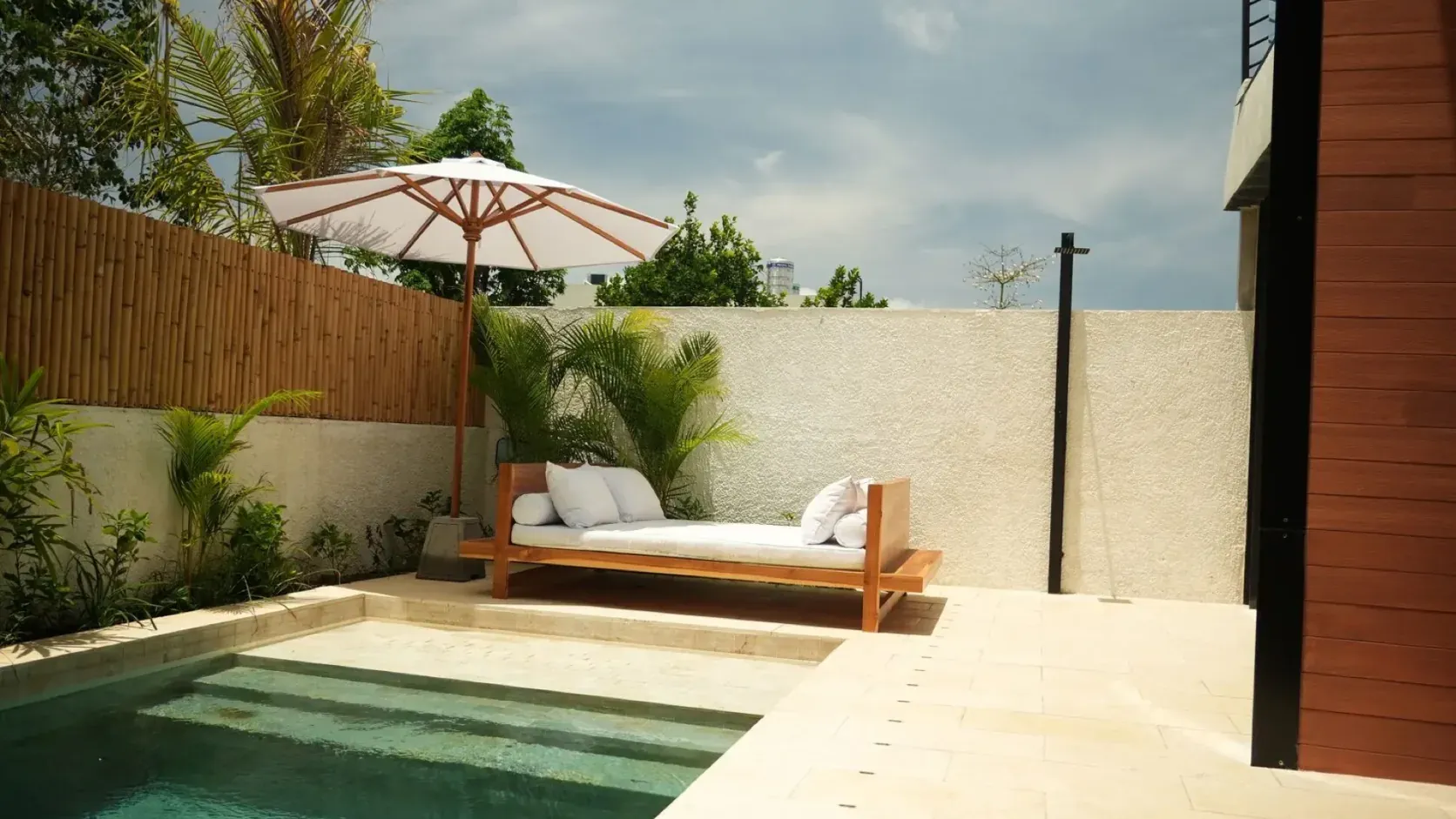 Private plunge pool, daybed and parasol in the walled garden of a Black Rock villa, prepared for rental guests