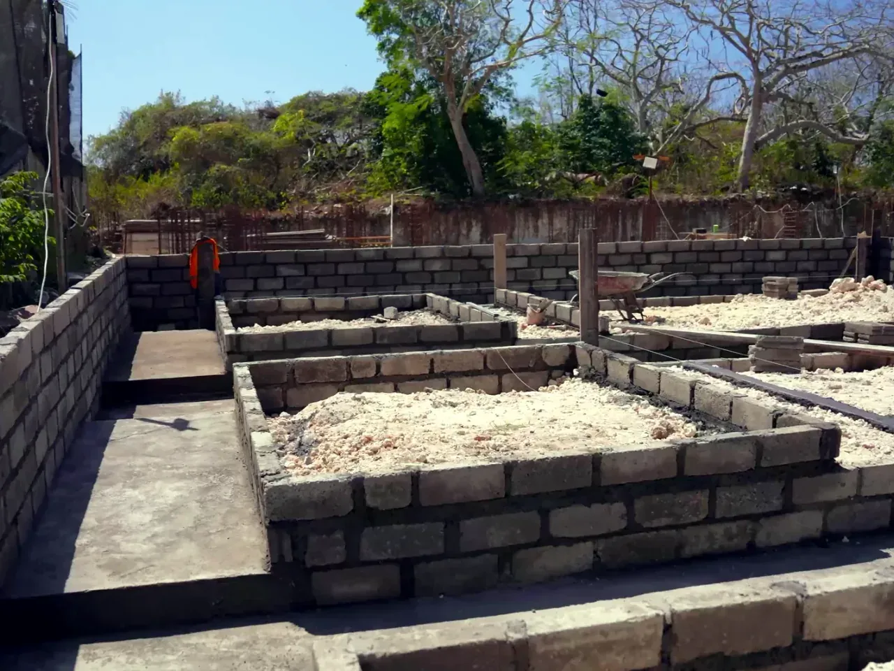 Stone foundation walls and backfilled footings at an early construction stage on the Satori site in Nusa Dua