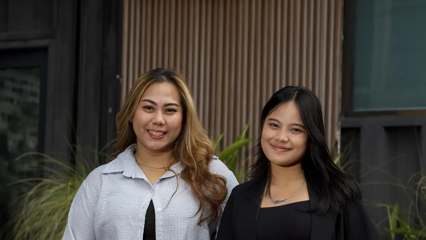 Two members of the HQC sales team smiling outside the company office in Bali